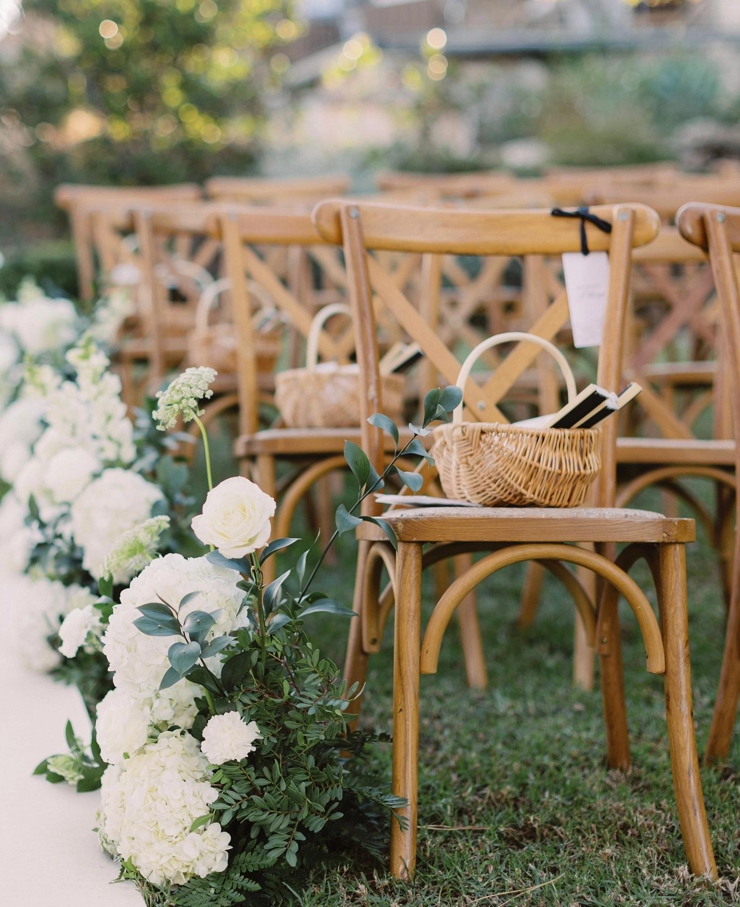 Chaises en bois avec des paniers en bois dessus et fleurs blanches aux Oliviers de Palombaggia en Corse-du-Sud.